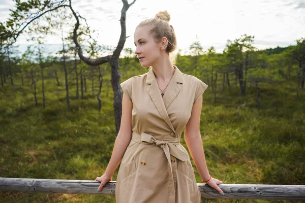 Porträt einer schönen nachdenklichen Frau im Kleid, die mit grünen Pflanzen im Hintergrund wegschaut — Stockfoto