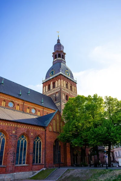 Escena urbana con calle de la ciudad, edificio y cielo azul nublado en Riga, Letonia - foto de stock