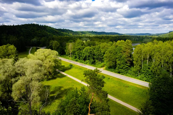 Vista panorámica del cielo azul nublado, carretera y árboles verdes, Riga, Letonia - foto de stock