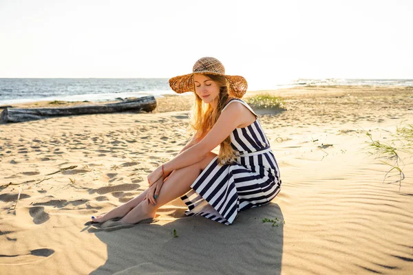 Attractive young woman in straw hat resting on sandy beach in Riga, Latvia — Stock Photo