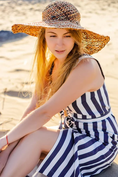 Portrait de jolie jeune femme en chapeau de paille reposant sur la plage de sable — Photo de stock