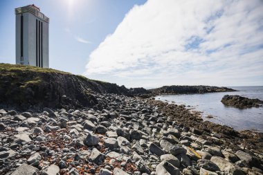 ışık evi ve bazalt taşların üzerinde kalfshamarsvik İzlanda üzerinde farklı renklerde