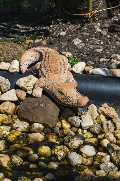 Plastic figure of a crocodile on the rock garden in germany
