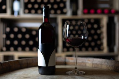 bir kiler, İsviçre bir varil üzerinde dolu bardaklı kırmızı şarap şişesi