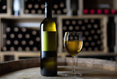 beyaz şarap şişesi bir kiler, İsviçre bir varil üzerinde dolu bardaklı