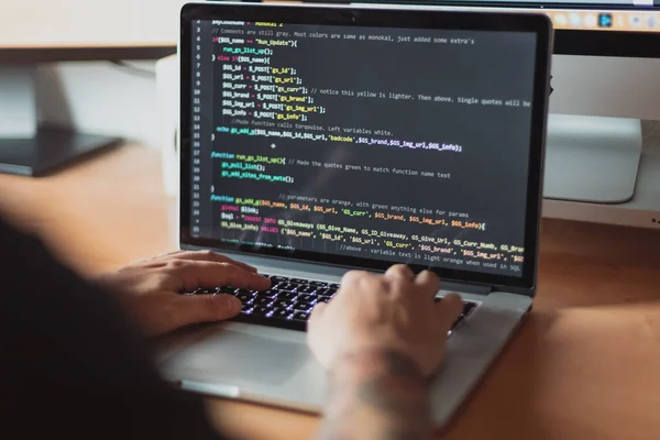 Laptop, programlanmış kod web, ahşap masa için çalışan adam