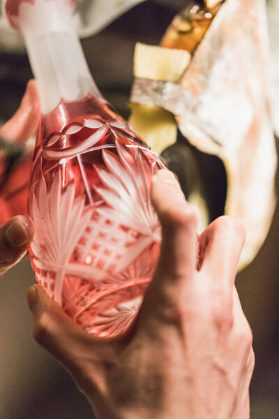 closeup of man grinding or cutting a colorful glass vase, germany
