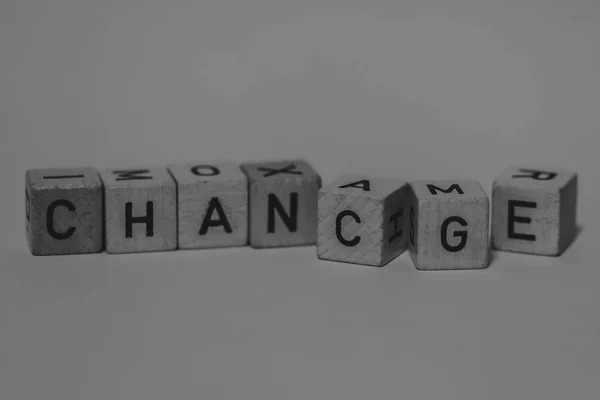 Macro shot of wooden cubes on a table showing the word CHANGE or — Stock Photo, Image