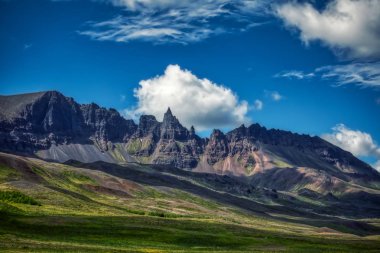 Görkemli dağlar, mavi gökyüzü ve İzlanda 'da büyük bulutlar