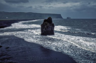 Dalgalar Vik köyünün yakınındaki siyah kumsala vuruyor.