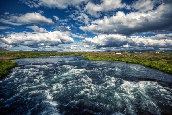 Потужна річка поруч з міваткою з блакитним небом і великими хмарами на айві — стокове фото