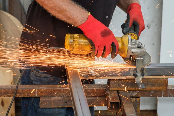 men working with hand grinder on metal construction