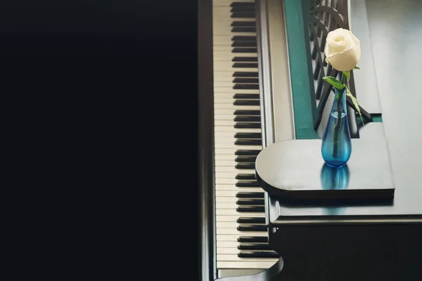 白色玫瑰在蓝色玻璃花瓶在大钢琴 — 图库照片