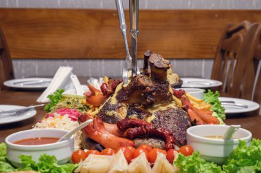 Soslar ve ahşap tahta üzerinde garnitür ile kavrulmuş domuz şaft