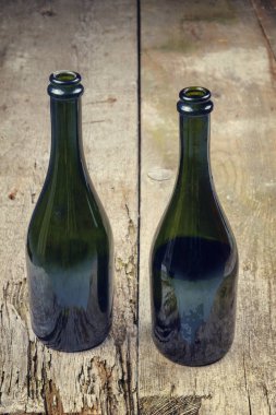 eski paslı ahşap masa üzerinde şarap şişeleri