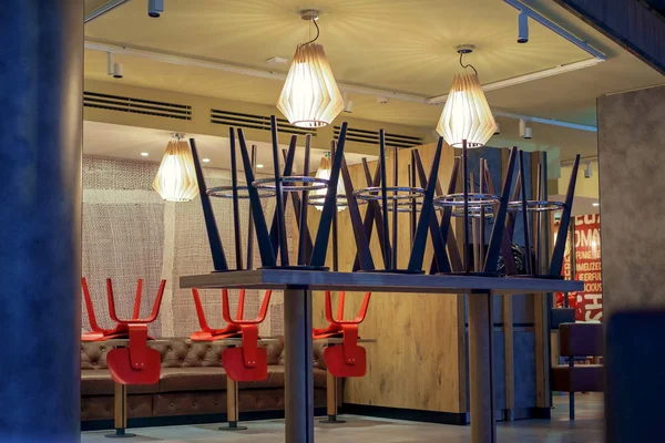 Upside down chairs in Interiour of closed cafe
