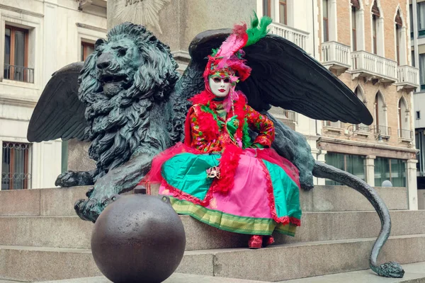 Donna in costume davanti alla scultura di leone alato — Foto Stock