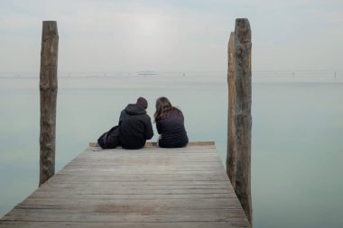 Ahşap iskelede sarılan çift