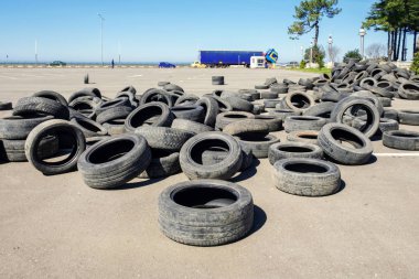 Asfalt üzerinde eski araba lastikleri yığını