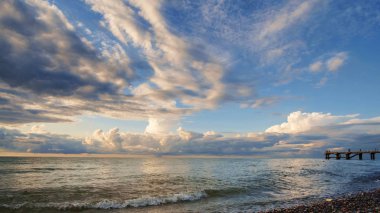 Sakin deniz üzerinde bulutlar ile Mavi gökyüzü