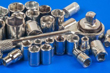 Priz anahtarı ve çeşitli anahtar başları mavi bir yüzeye yakın çekim