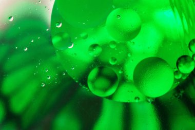 Değişken yeşil renklere sahip renkli soyut arkaplan, su kabarcıkları içindeki yağ damlaları