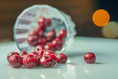 Koyu arkaplanlı beyaz yüzeydeki camda donmuş kiraz. seçici odak 