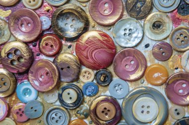 Boyalı bir yüzeydeki kıyafetler için farklı renk düğmeleri. Yakın plan.