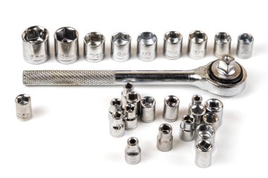 Soket anahtarı ve çeşitli anahtar başları beyaz bir yüzeye yakın çekim