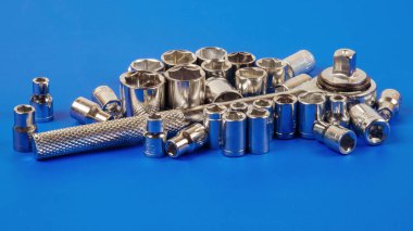 Priz anahtarı ve çeşitli anahtar başları mavi bir yüzeye yakın çekim