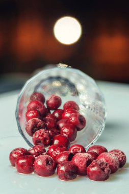 Koyu arkaplanlı beyaz yüzeydeki buzlu kirazın yakın plan görüntüsü. seçici odak 