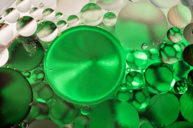 Yeşil ve bej rengi gradyanı olan renkli soyut arkaplan, su kabarcıkları içinde yağ damlaları