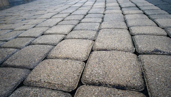 Detail of vintage traditional stone pavement in perspective. Abstract background of old cobblestone pavement