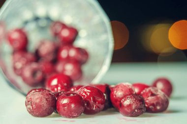 Koyu arkaplanlı beyaz yüzeydeki buzlu kirazın yakın plan görüntüsü. seçici odak 