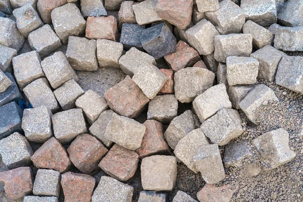 屋外舗装タイルを作るためのほこりっぽい色の天然石のキューブの山 — ストック写真