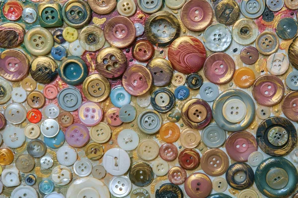 Different color various buttons for clothes on a painted surface. Close-up