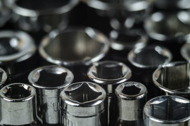 Çeşitli boyutlarda metal anahtar başları yakın plan. İngiliz anahtarı başlıkları koleksiyonu, seçici odak