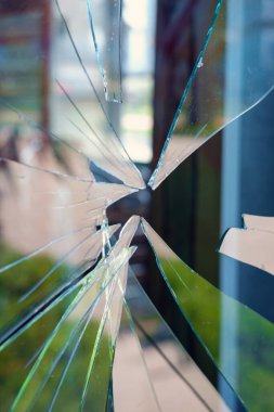 Tozlu cam kırıkları, iç mekan bulanık doğa manzarasını yansıtıyor.