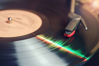 Yeşil ve kırmızı ışıkları yansıtan dönen siyah vinil plaklı Retro kayıt çalar