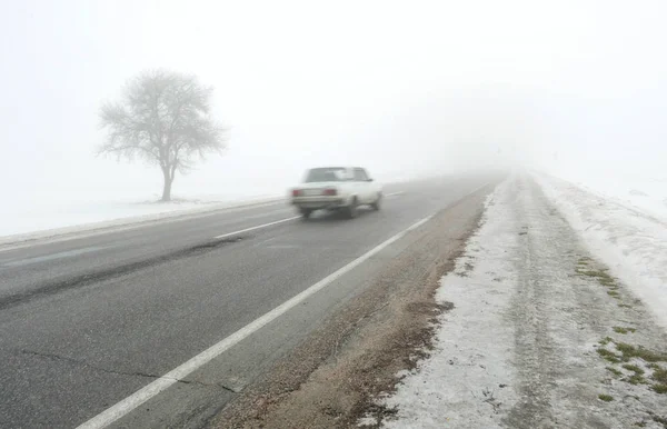 car goes on a bad road to fog