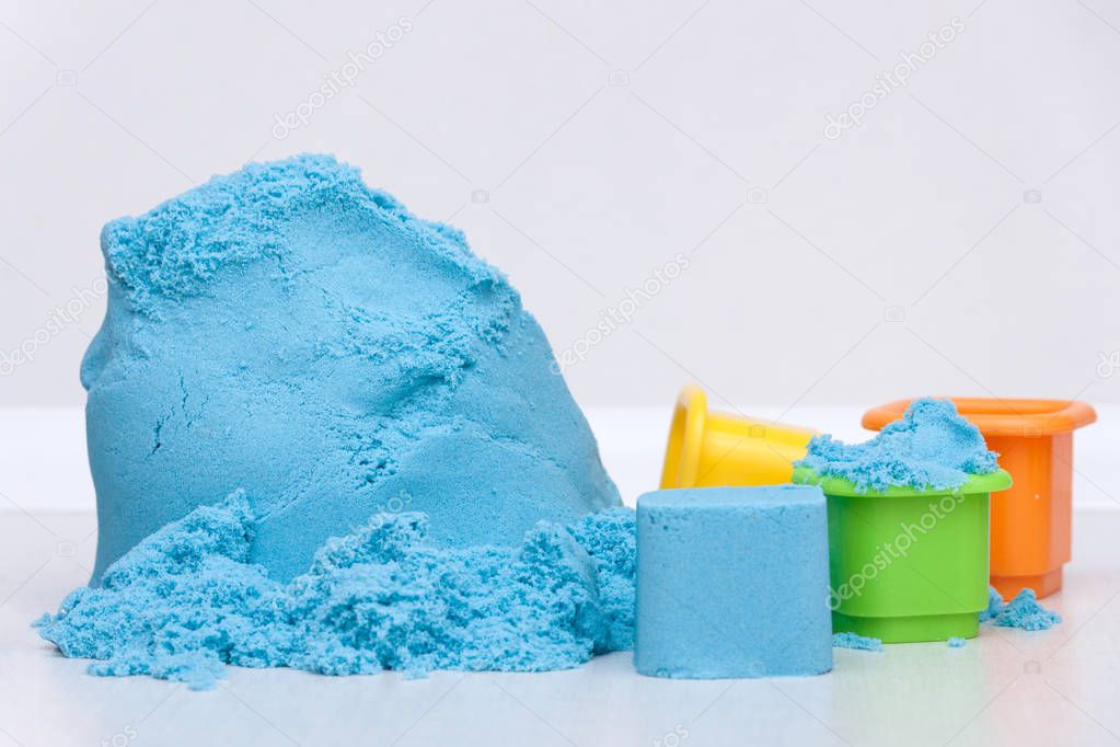 Kids education plastic toys and kinetic sand on the white background. Copy space