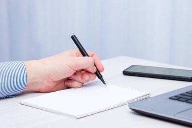 Solak adam deftere yazıyor. Solak Günü konsepti.