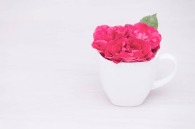 Çiçekler ahşap arka planda bir kapta kırmızı güller. Düz yatış, üst görünüm, çiçek arkaplan, tonlama.