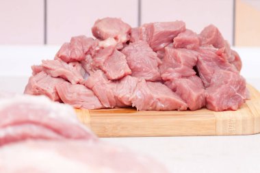 Kesme tahtasındaki çiğ domuz eti parçaları. Hazırlanıyor, pişiriliyor..