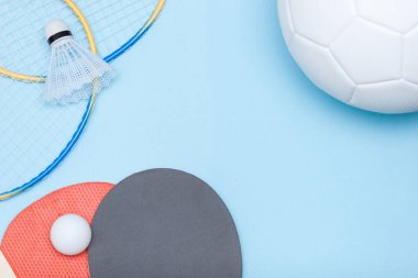 Futbol topu, badminton, masa tenisi ekipmanları. Farklı spor konseptleri arasında seçim yapmak.