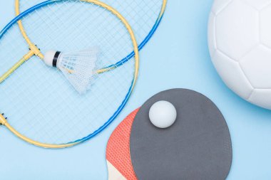 Futbol topu, badminton, masa tenisi ekipmanları. Farklı spor konseptleri arasında seçim yapmak.