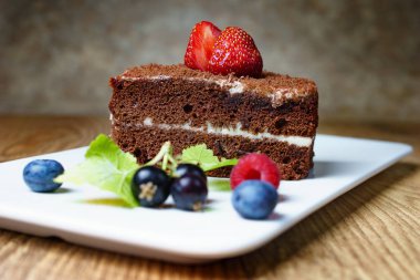 Asty çikolata tatlı çilek, berry, ahududu, yaban mersini, bilberry bir dizi ile bir porselen destek.