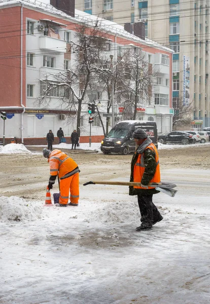 雪がたくさんです 冬のロシアのベルゴロド市における雪のクリーニング 労働者は 雪を掻きます 雪からの道路の清掃 — ストック写真