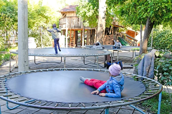 Children play with trampolines in a public park. Autumn.
