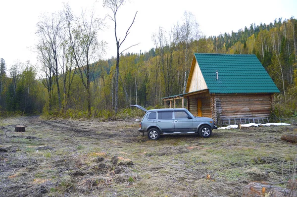 SUV in the wooded mountains, near the hunting lodge. Russia